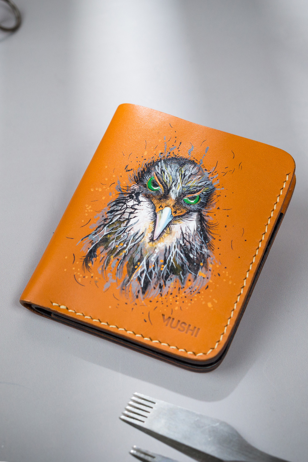 Hawk Eyes-Featured-Image Genuine minimalist leather wallet with pull-out strap in beige with hawk painting in Pakistan.