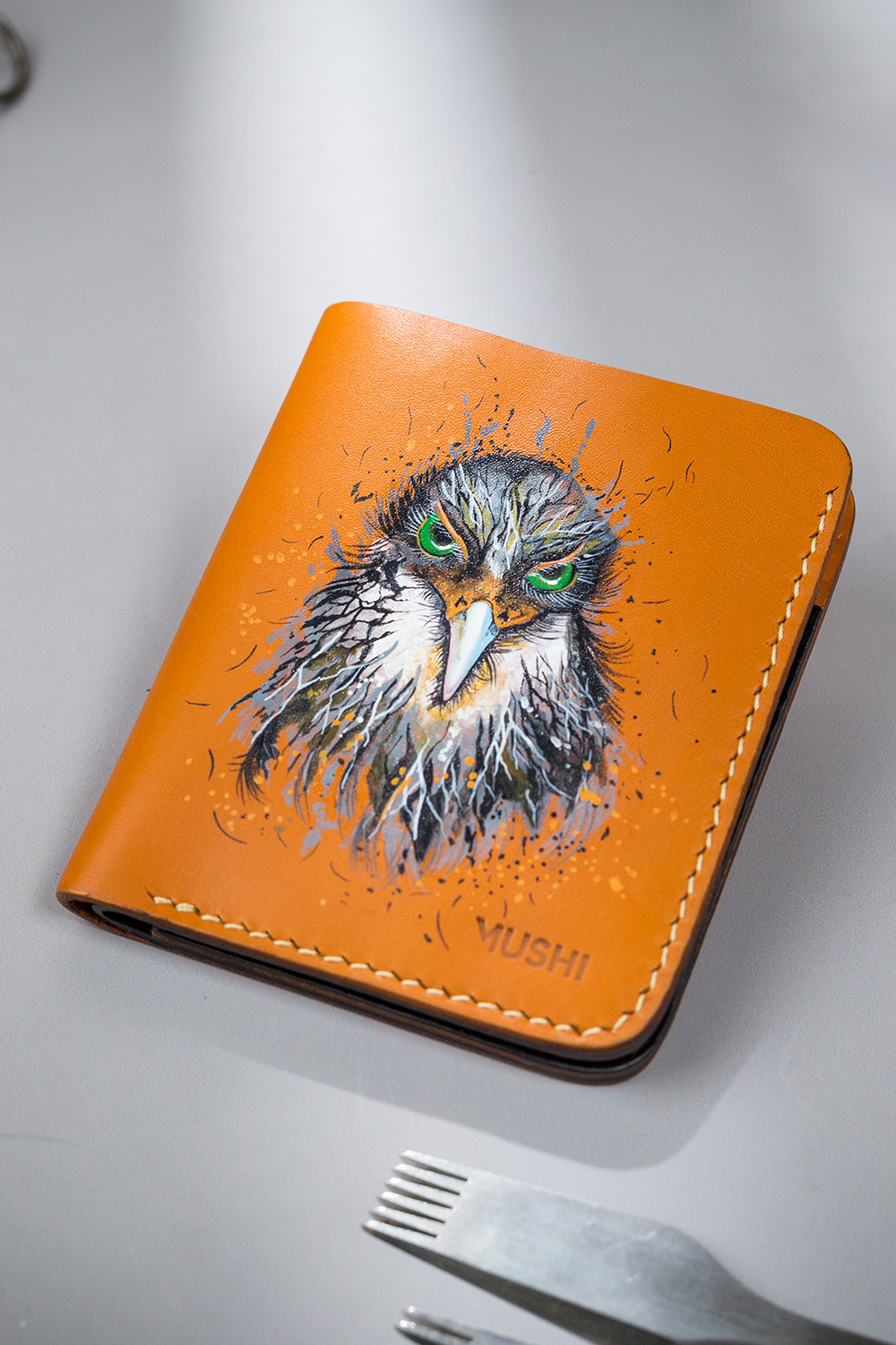 HAWK-EYES-FOOTER-IMAGE-TWO Genuine minimalist leather wallet with pull-out strap in beige with hawk painting in Pakistan.
