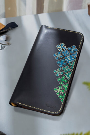 Handcrafted leather wallet with green and blue design.