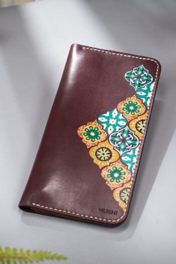 Handcrafted burgundy wallet featuring detailed pattern art on leather