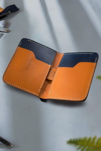 Pure handmade orange and black Leather Wallet stitching by Hands